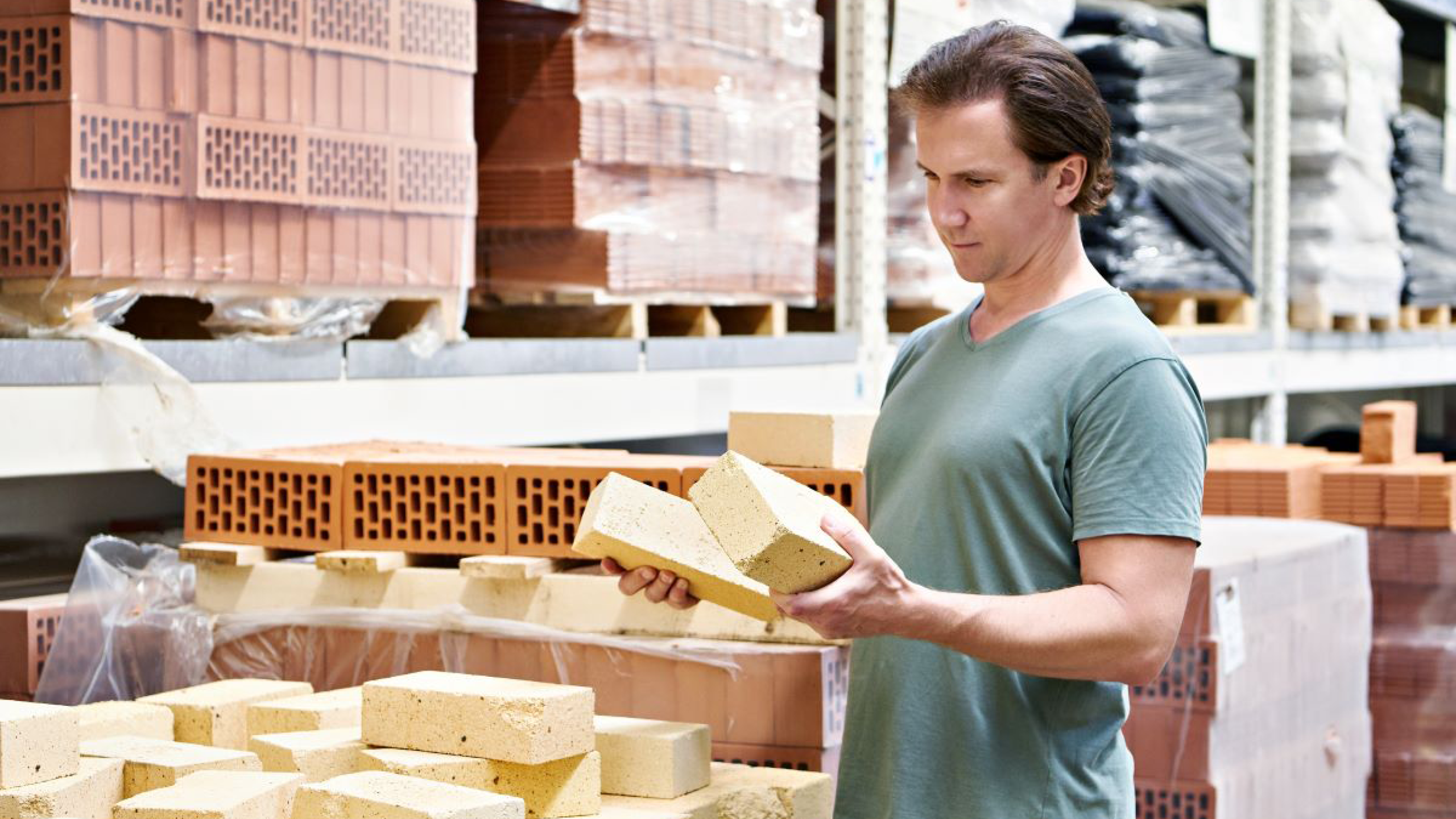 Man met bakstenen in de hand