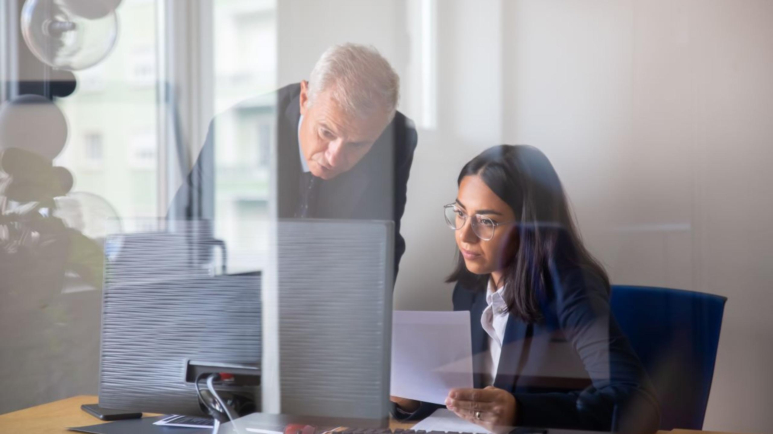 Man en vrouw kijken naar computerscherm