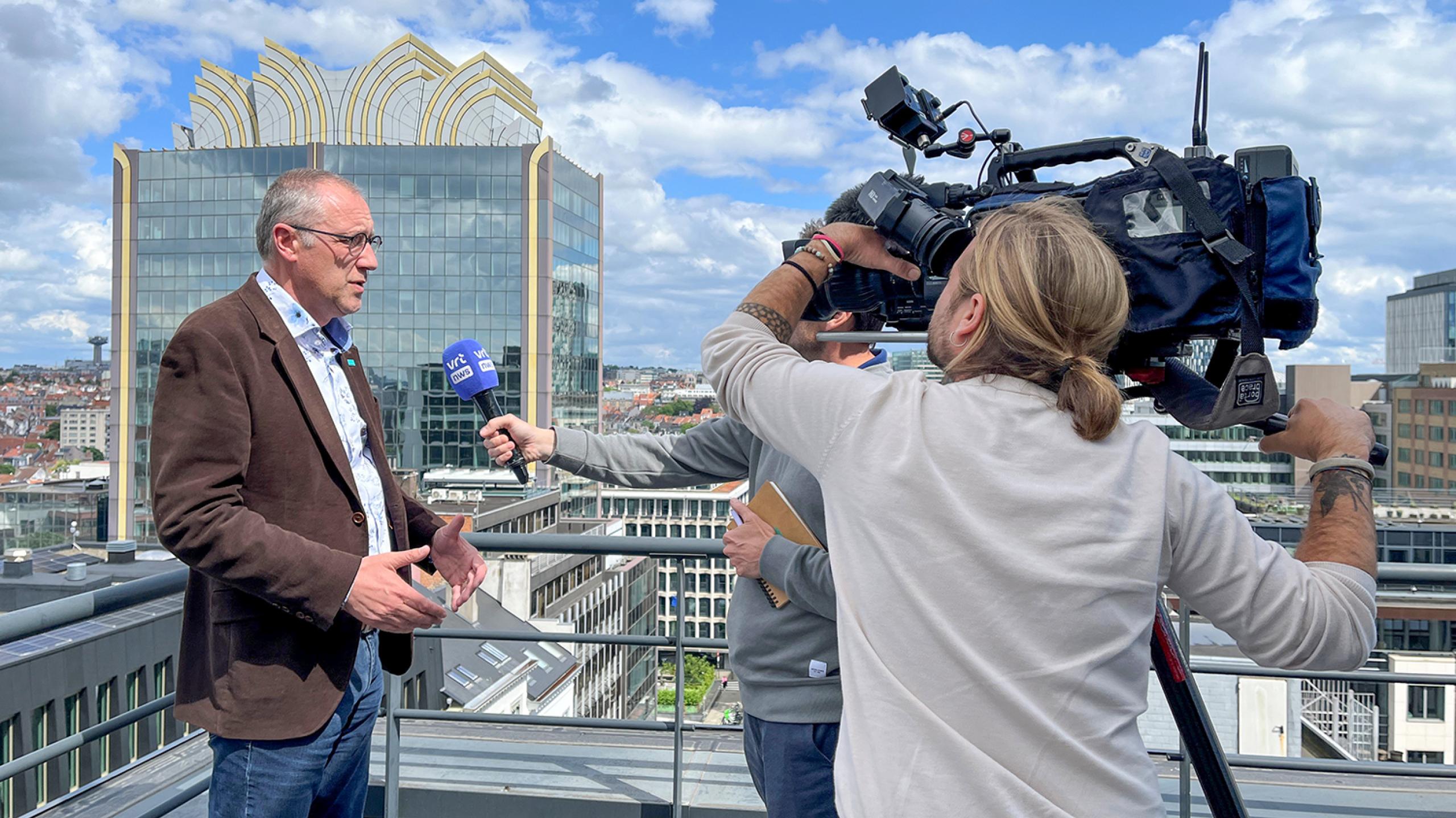 Niko Demeester met cameraploeg VRT op dak van Embuild in Brussel.