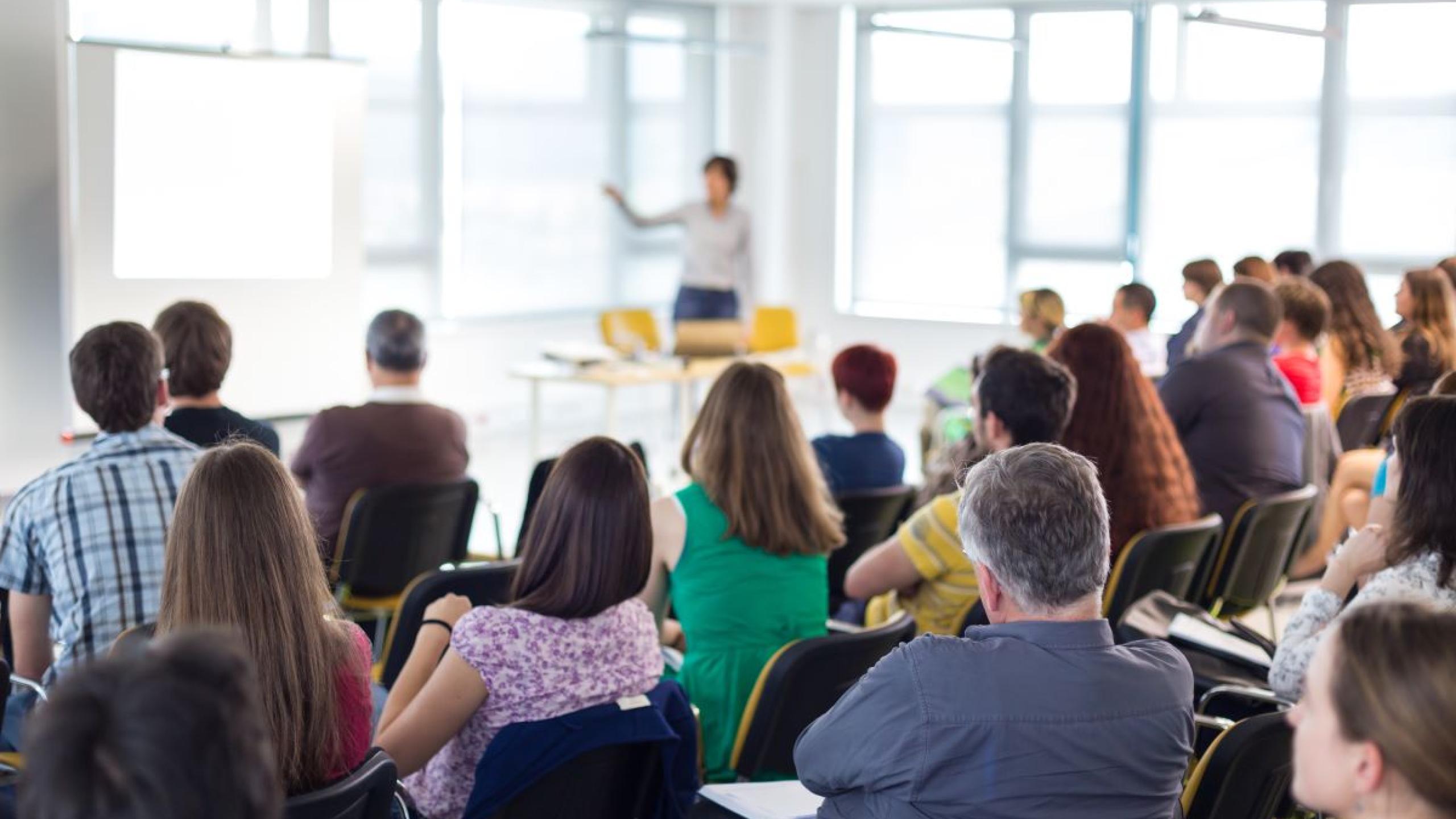 Volwassen studenten in aula luisteren naar docent.