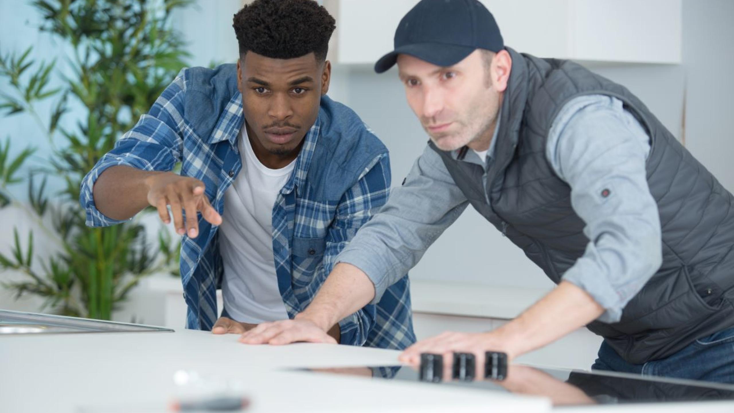 Student en vakman geconcentreerd aan de slag.