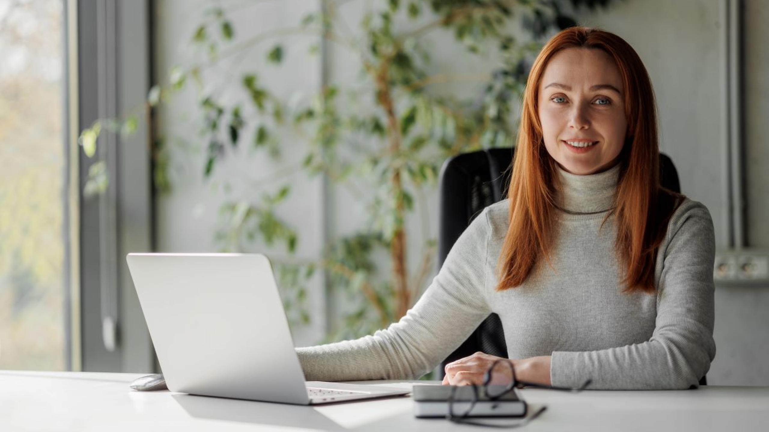 Jonge vrouw met laptop op kantoor. 